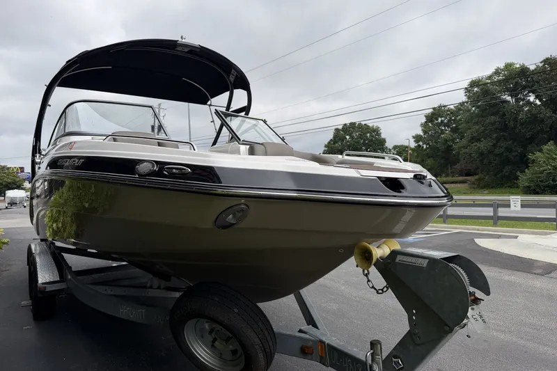 Slide: The Image of 2012 Yamaha 242 Limited S boat on trailer, parked outdoors with trees in background. - 3