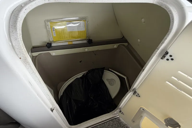 Slide: The Image of Storage compartment with a portable toilet in a 2012 Yamaha 242 Limited S boat. - 8