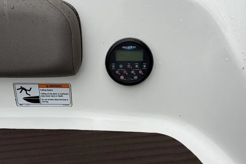 Slide: The Image of 2012 Yamaha 242 Limited S boat dashboard with Aquatic AV control panel and safety warning label. - 7