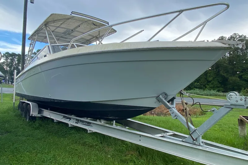 The Image of 2001 Contender 35 Express boat on trailer, parked on grass, under cloudy sky. - 1