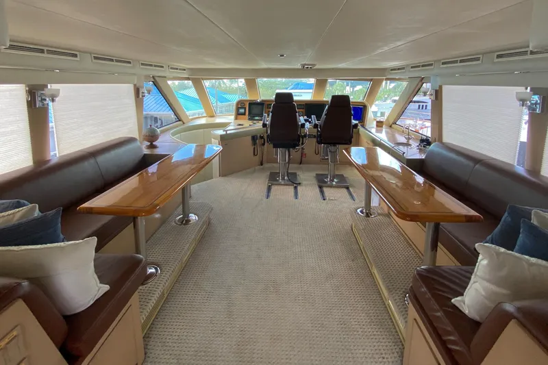 Slide: The Image of Luxurious 1996 Hatteras yacht interior with plush seating, wooden tables, and modern navigation equipment. - 24