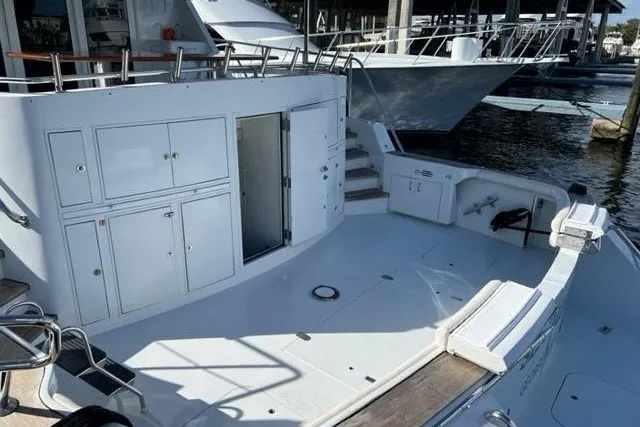 Slide: The Image of 1996 Hatteras yacht deck with storage cabinets and open hatch, docked at marina. - 33