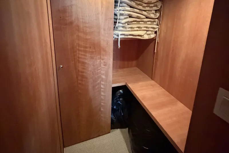 Slide: The Image of Wooden interior storage space on a 1996 Hatteras boat with stacked cushions. - 13