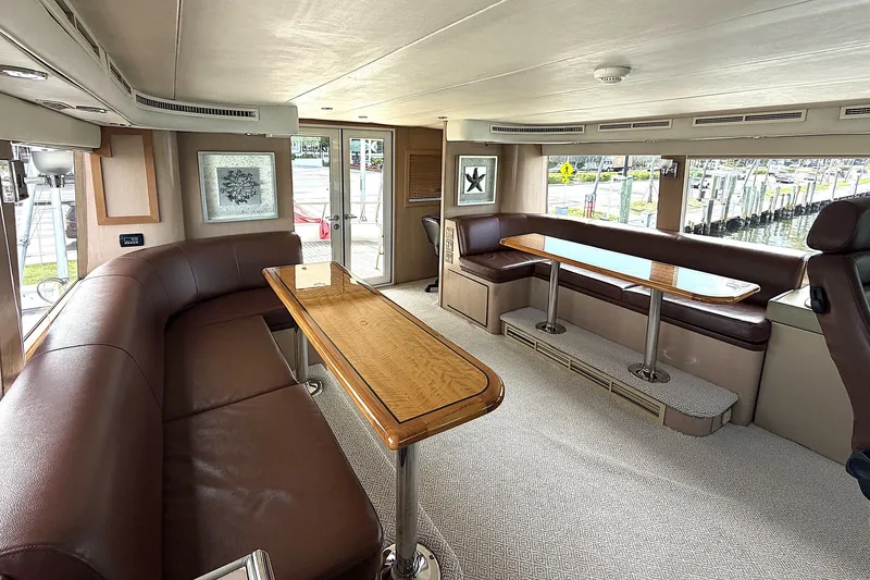 Slide: The Image of Luxurious 1996 Hatteras yacht interior with leather seating and wooden tables. - 25