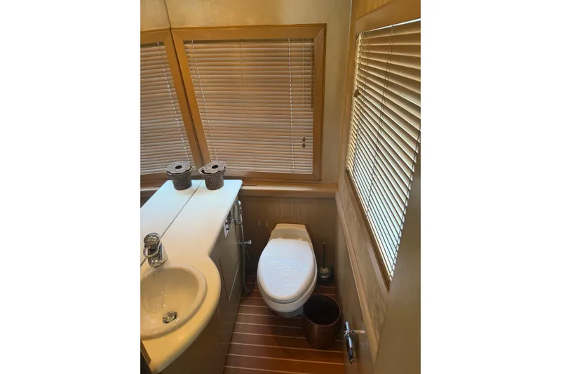 Slide: The Image of Bathroom interior of a 1996 Hatteras yacht with wooden blinds and modern fixtures. - 28