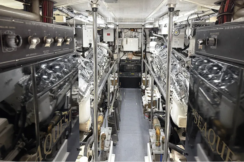 Slide: The Image of Engine room of a 1996 Hatteras yacht, featuring dual engines and control panels. - 37