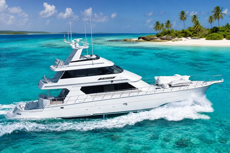 The Image of Luxury 1996 Hatteras yacht cruising in turquoise waters near tropical island. - 0