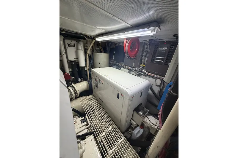 Slide: The Image of Engine room of a 1996 Hatteras boat, featuring machinery and control panels. - 40