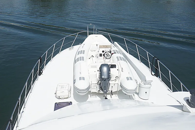 Slide: The Image of Bow view of a 1996 Hatteras yacht with inflatable boat and calm waters. - 36