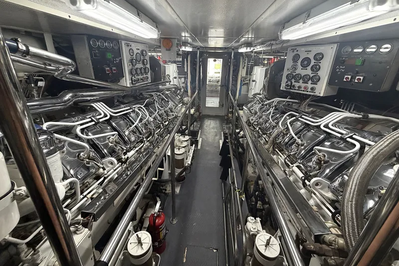 Slide: The Image of Engine room of a 1996 Hatteras yacht, featuring dual engines and control panels. - 38