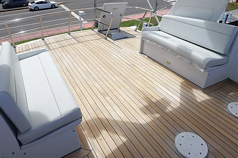 Slide: The Image of Spacious deck of a 1996 Hatteras yacht with cushioned seating and wooden flooring. - 31