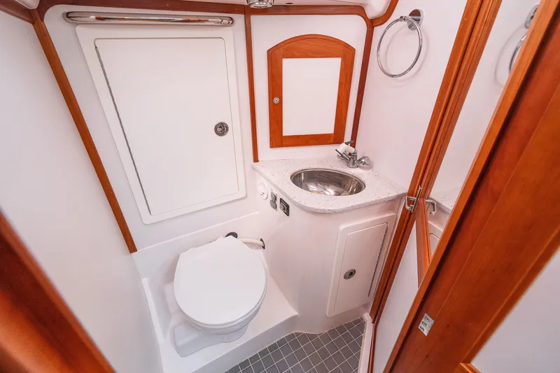 Slide: The Image of Compact bathroom in 2013 Sabre 456 yacht with sink, toilet, and wooden accents. - 24