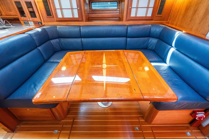 Slide: The Image of Luxurious Sabre 456 yacht interior with blue leather seating and polished wooden table, 2013 model. - 13