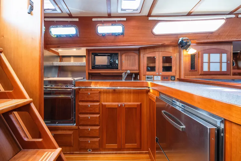 Slide: The Image of Luxurious 2013 Sabre 456 yacht interior with wooden cabinetry and modern kitchen appliances. - 7