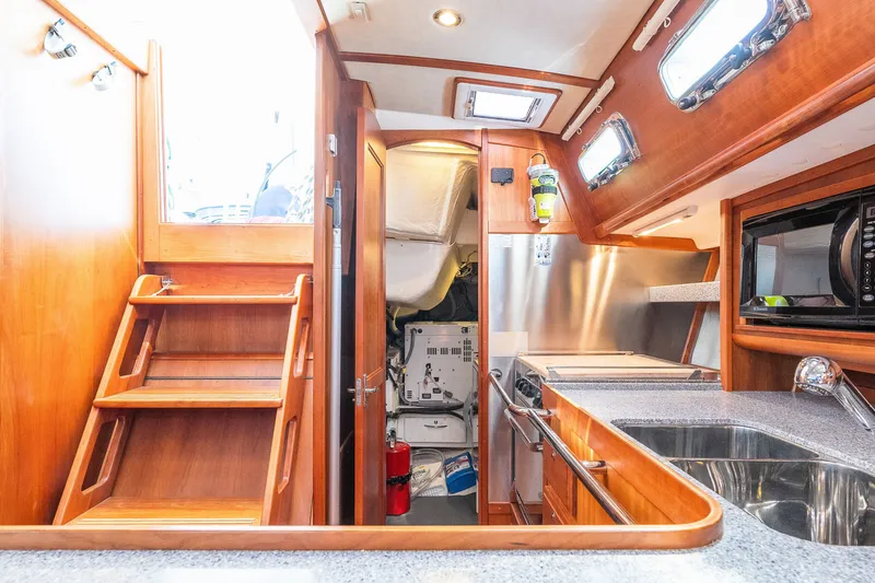 Slide: The Image of Interior of 2013 Sabre 456 yacht featuring wooden cabinetry and modern kitchen amenities. - 21