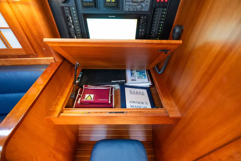 Slide: The Image of Navigation station with manuals and equipment in a 2013 Sabre 456 yacht. - 23