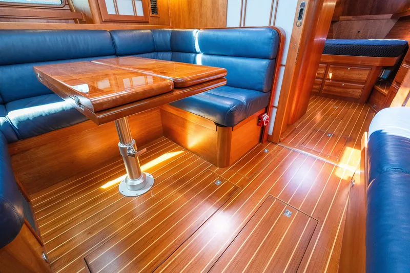 Slide: The Image of Luxurious 2013 Sabre 456 yacht interior with wooden flooring and blue leather seating. - 14