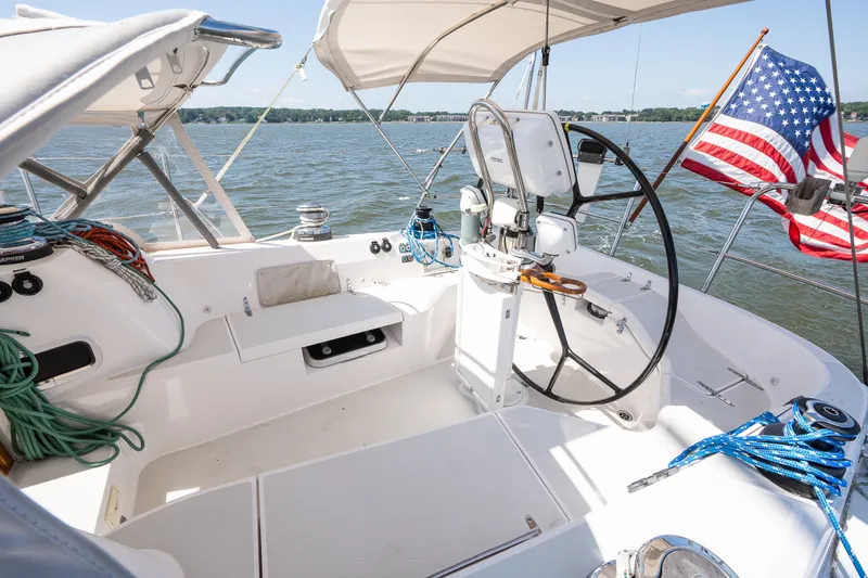 Slide: The Image of Sailboat cockpit with steering wheel, ropes, and American flag on a sunny day. Sabre 456, 2013. - 58