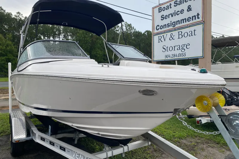 The Image of 2017 Regal 1900 ES Bowrider on trailer near boat sales and storage sign. - 1
