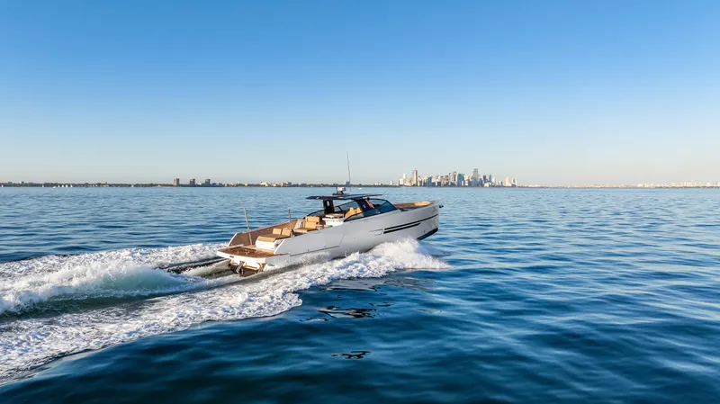 Slide: The Image of A modern 2026 OKEAN 57 boat speeds across the water with a city skyline in the background. - 50