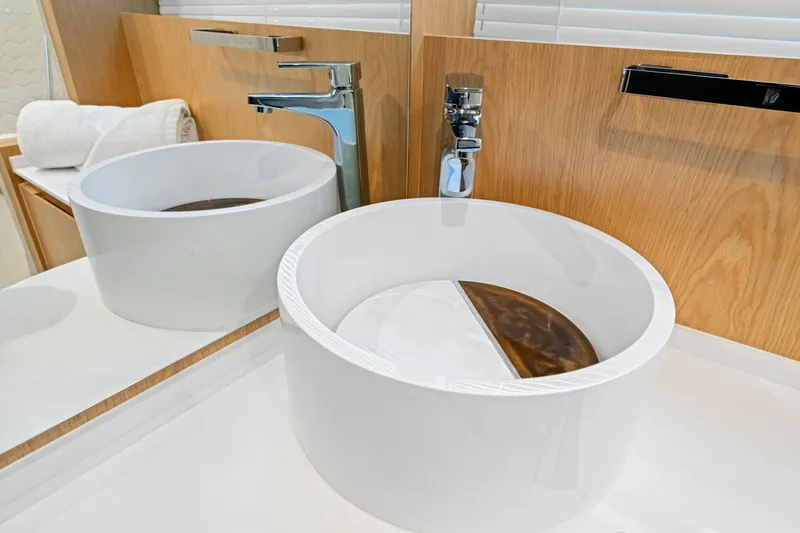 Slide: The Image of Modern bathroom sink on OKEAN 52 yacht, 2025 model, with sleek faucet and wooden accents. - 64