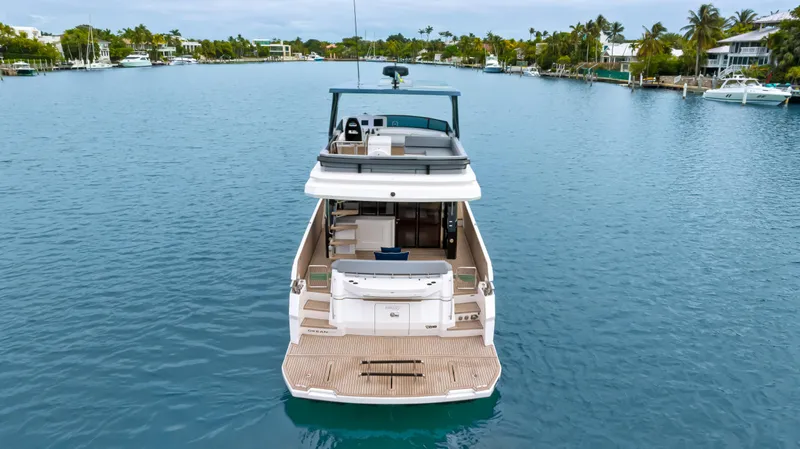 Slide: The Image of 2025 OKEAN 52 yacht on serene waterway, rear view. - 25