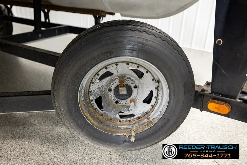 Slide: The Image of Rusty wheel of a 2003 Fisher 220 FISH trailer in a garage setting. - 33