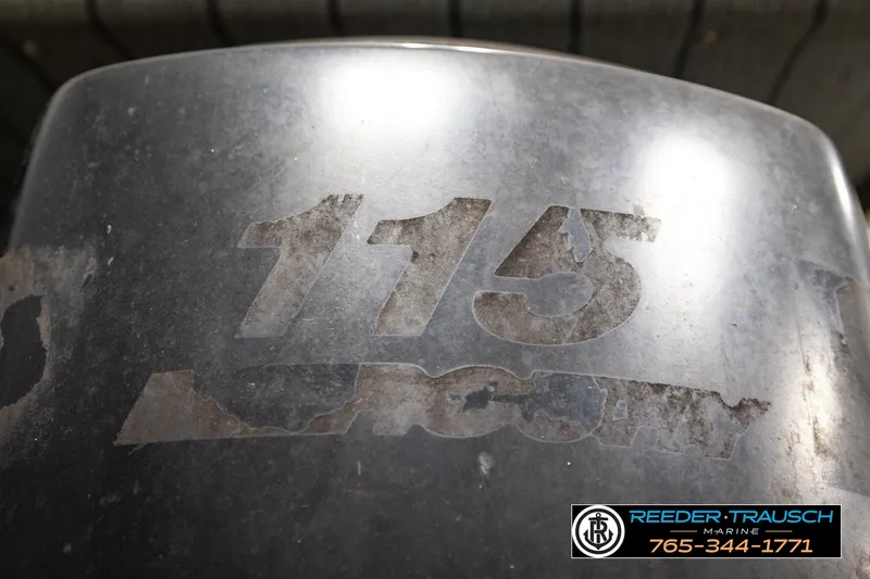 Slide: The Image of Outboard motor with "115" marking on a Fisher 220 FISH, 2003 model. - 31