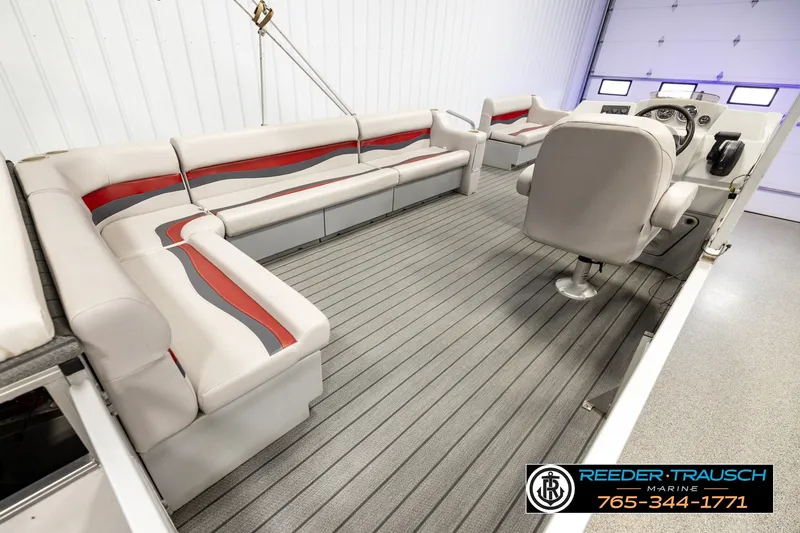 Slide: The Image of 2003 Fisher 220 FISH boat interior with gray and red seating, steering console, and spacious layout. - 12