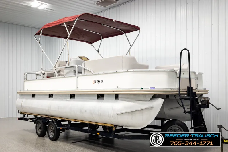Slide: The Image of 2003 Fisher 220 FISH pontoon boat with red canopy on trailer in indoor storage. - 3