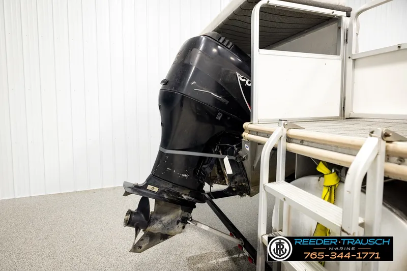 Slide: The Image of Outboard motor on a 2003 Fisher 220 FISH boat in a showroom setting. - 30
