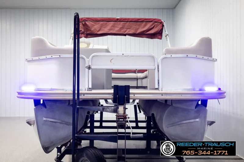 Slide: The Image of 2003 Fisher 220 FISH pontoon boat on trailer, indoor storage, blue lights, Reeder Trausch Marine. - 8