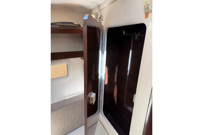 Slide: The Image of Interior cabin of 2016 Sea Ray Sundancer 260 with open wooden cabinet. - 47