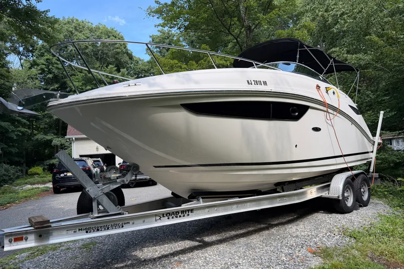 Slide: The Image of 2016 Sea Ray Sundancer 260 boat on trailer in wooded driveway. - 9