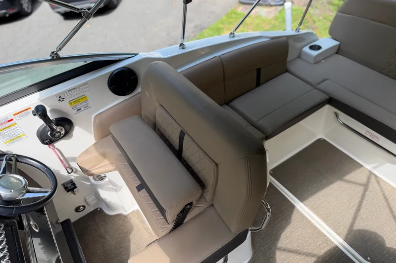 Slide: The Image of Interior of a 2016 Sea Ray Sundancer 260 boat, featuring beige seating and steering controls. - 33