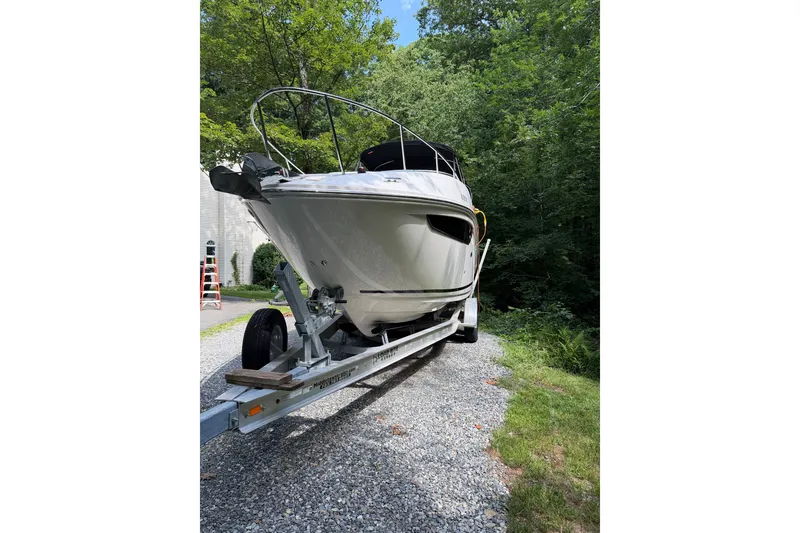 Slide: The Image of 2016 Sea Ray Sundancer 260 boat on trailer, surrounded by lush greenery. - 7