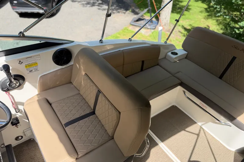 Slide: The Image of 2016 Sea Ray Sundancer 260 interior with beige seating and steering wheel. - 32