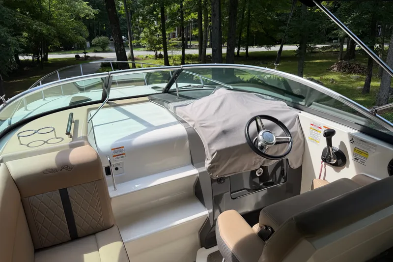 Slide: The Image of 2016 Sea Ray Sundancer 260 cockpit with covered steering wheel and comfortable seating. - 23