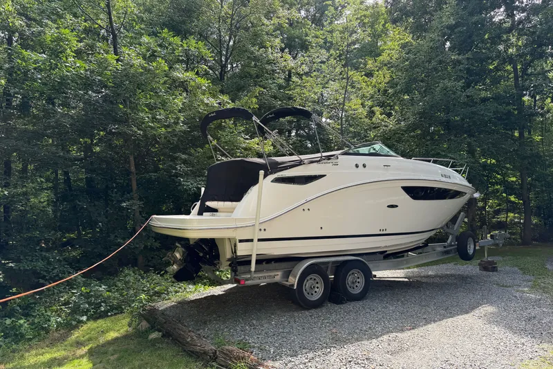 Slide: The Image of 2016 Sea Ray Sundancer 260 boat on trailer in wooded area. - 18