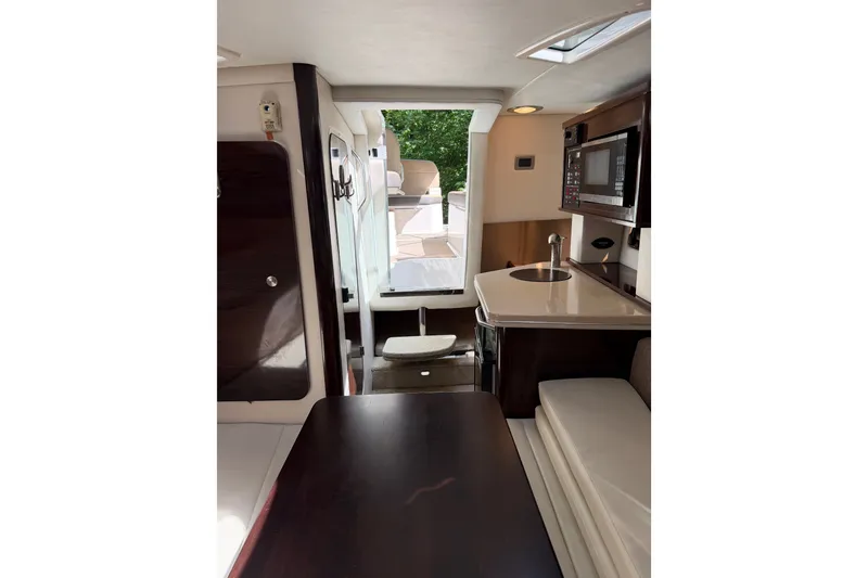 Slide: The Image of Interior of 2016 Sea Ray Sundancer 260, featuring kitchenette and seating area. - 36