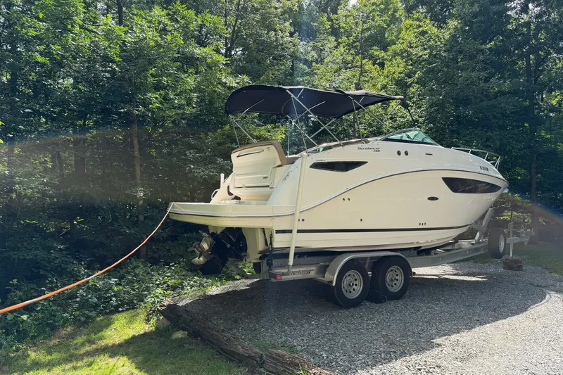Slide: The Image of 2016 Sea Ray Sundancer 260 boat on trailer, parked in a wooded area. - 14