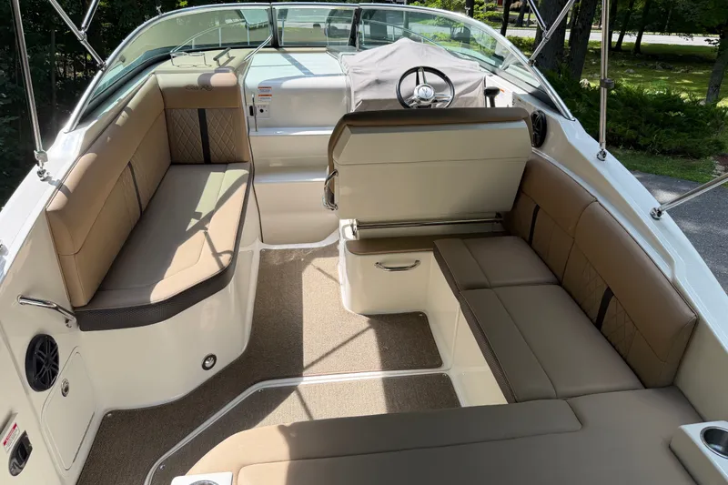 Slide: The Image of Interior of a 2016 Sea Ray Sundancer 260 boat with tan seating and steering wheel. - 25