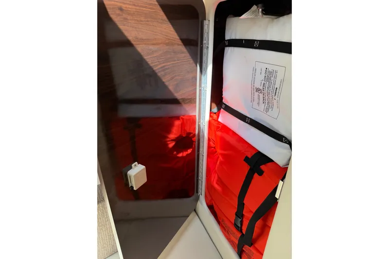 Slide: The Image of Storage compartment with life jackets on a 2016 Sea Ray Sundancer 260 boat. - 48