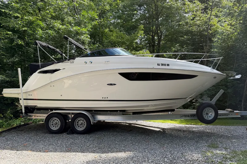 Slide: The Image of 2016 Sea Ray Sundancer 260 boat on trailer, surrounded by lush greenery. - 19