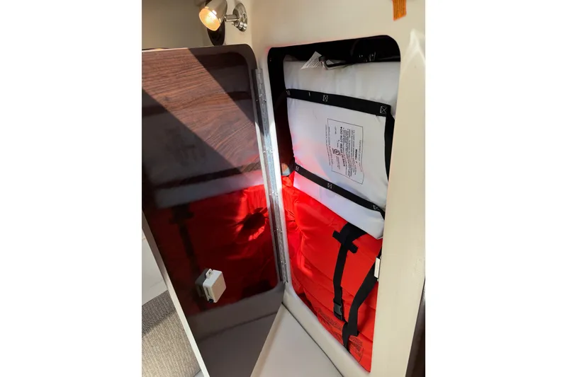 Slide: The Image of Storage compartment with life jackets on a 2016 Sea Ray Sundancer 260 boat. - 49
