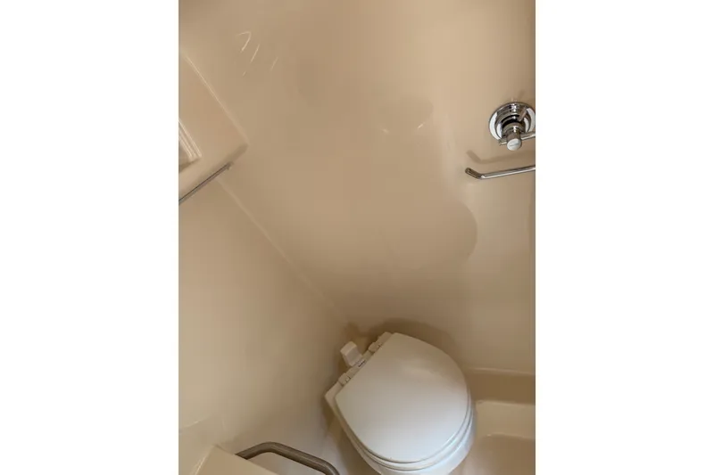 Slide: The Image of Bathroom interior of 2016 Sea Ray Sundancer 260 boat, featuring a compact toilet. - 52