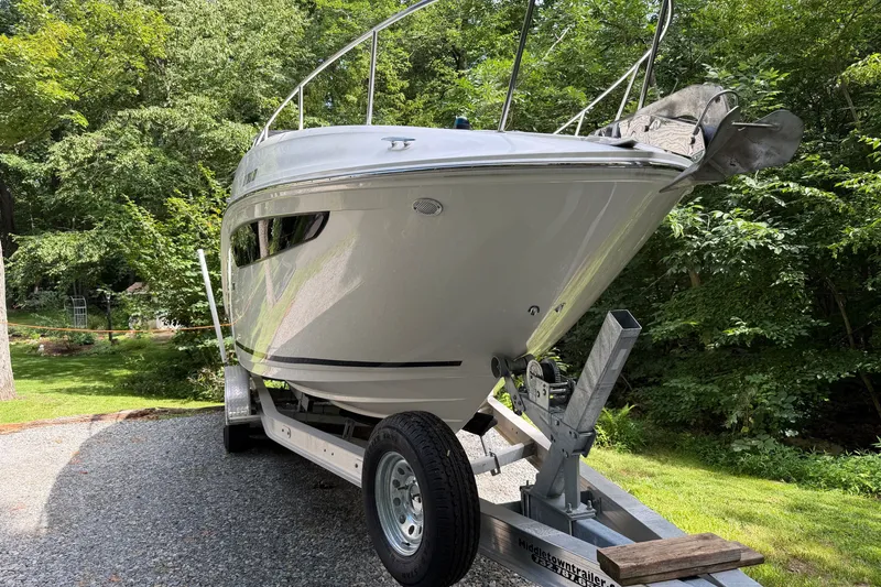 Slide: The Image of 2016 Sea Ray Sundancer 260 boat on trailer, surrounded by lush greenery. - 21