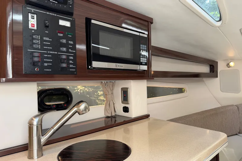 Slide: The Image of Interior of 2016 Sea Ray Sundancer 260 yacht with kitchen amenities and control panel. - 56