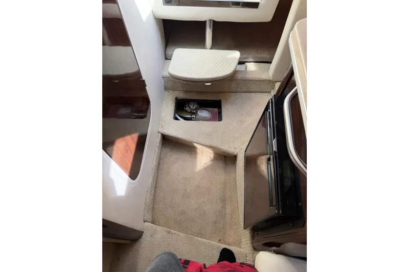 Slide: The Image of Interior view of 2016 Sea Ray Sundancer 260 cabin with carpeted flooring and compact fridge. - 35