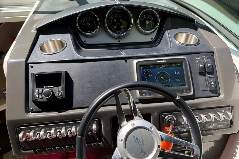 Slide: The Image of Dashboard of a 2016 Sea Ray Sundancer 260 boat with navigation controls. - 44